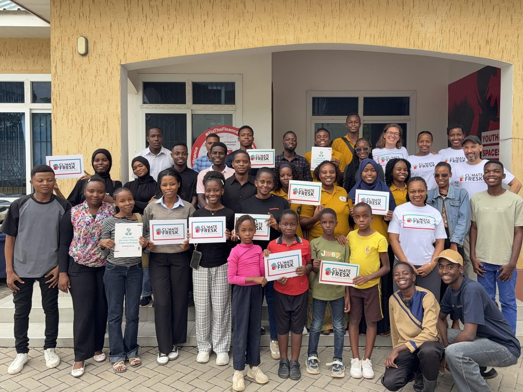 Climate Fresk participants and facilitators holding certificates outside the workshop venue.