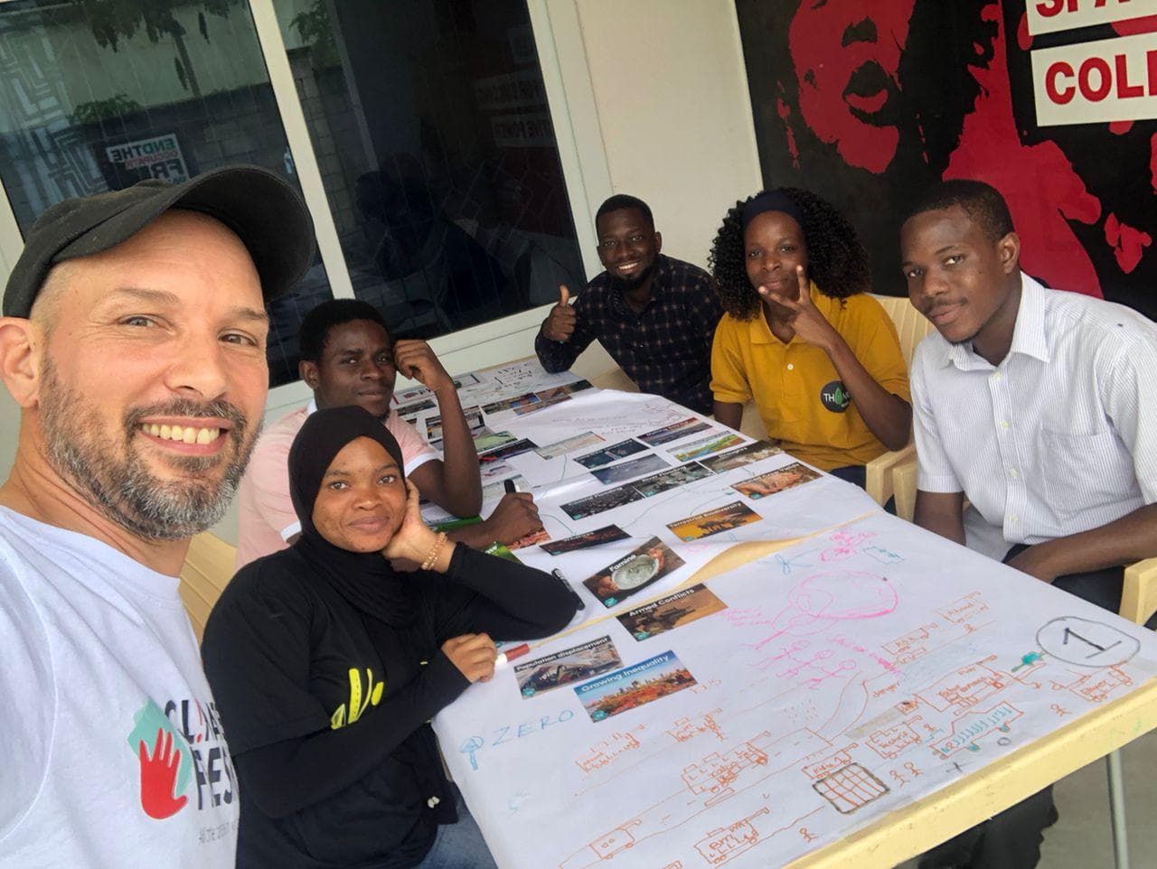 A facilitator and participants beside a completed climate systems diagram.