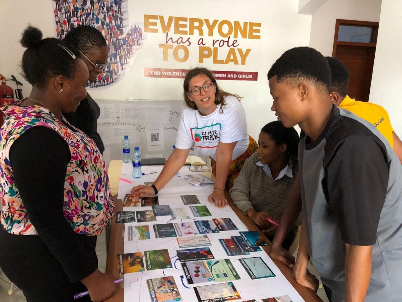 A facilitator supporting participants as they discuss and connect Climate Fresk cards.
