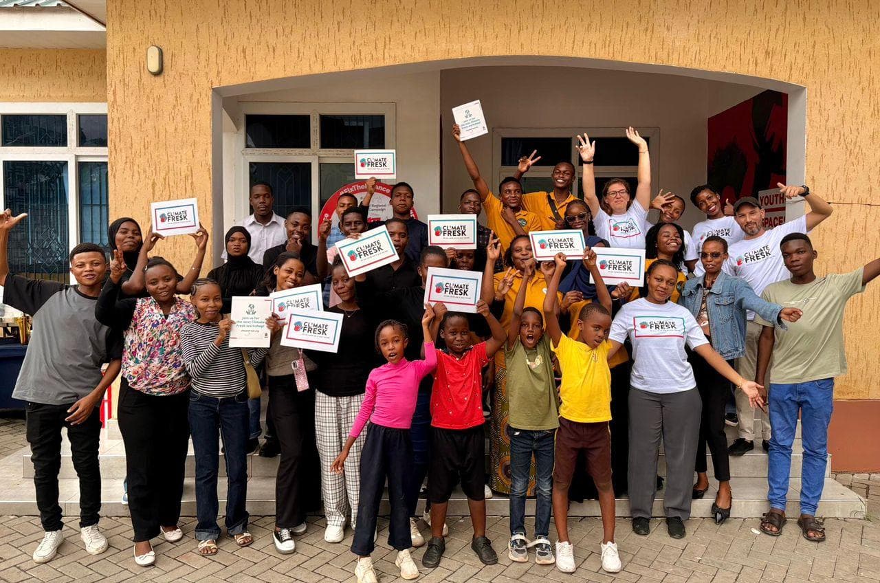 Workshop participants celebrating with raised arms and certificates outside the venue.