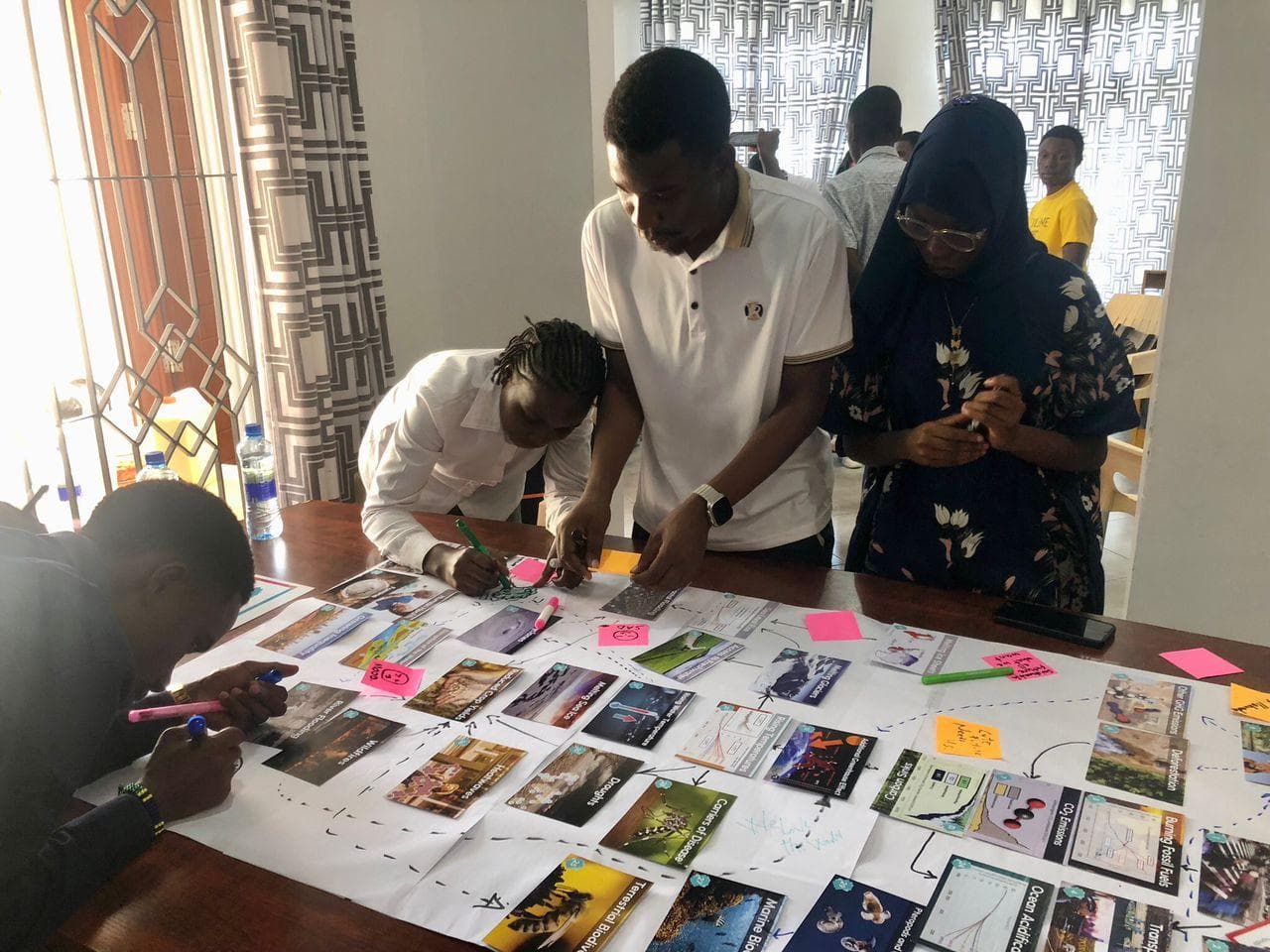 Participants studying and arranging climate cards during a workshop session.