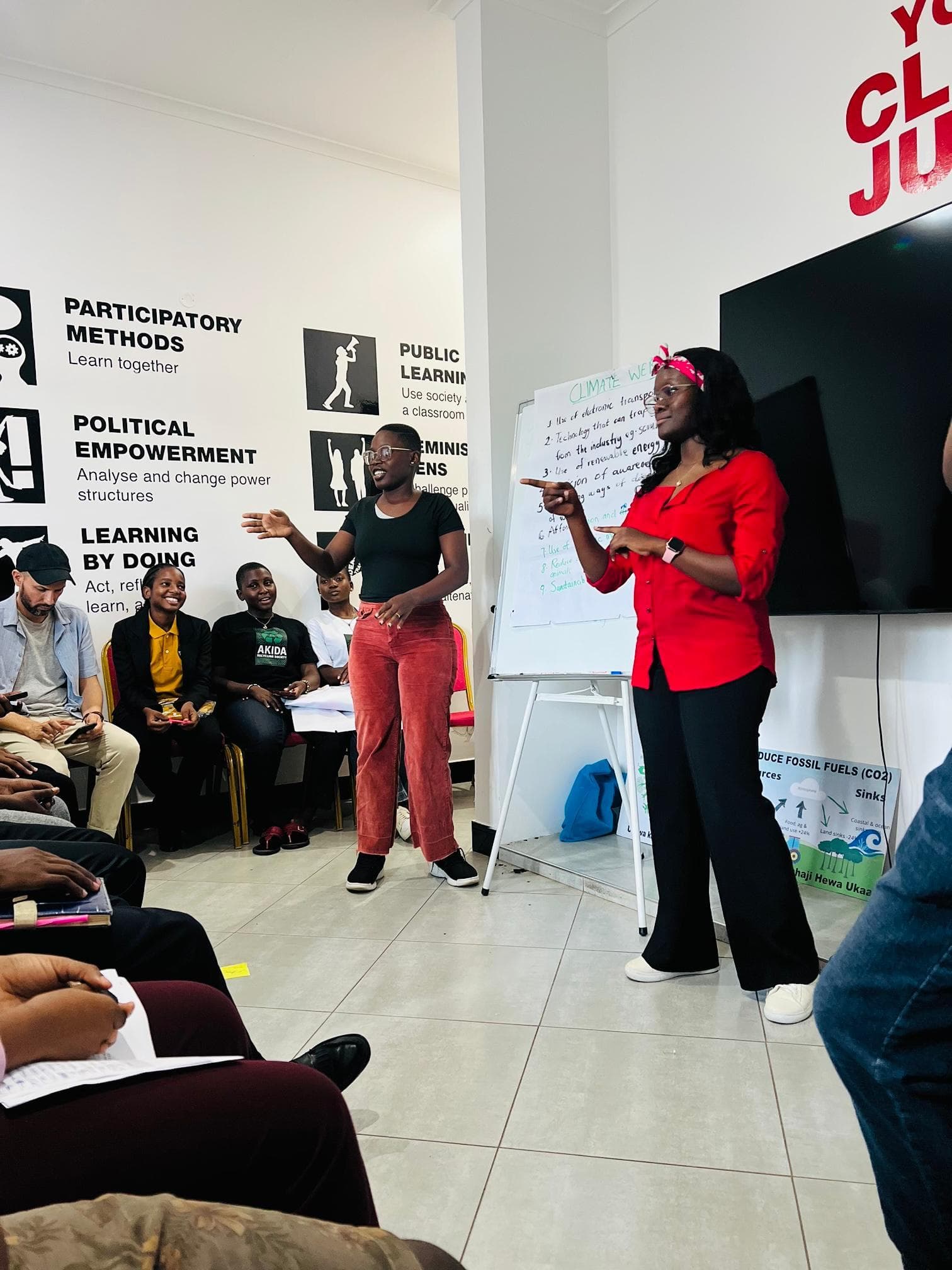 A participant in a red top addressing the seated group.