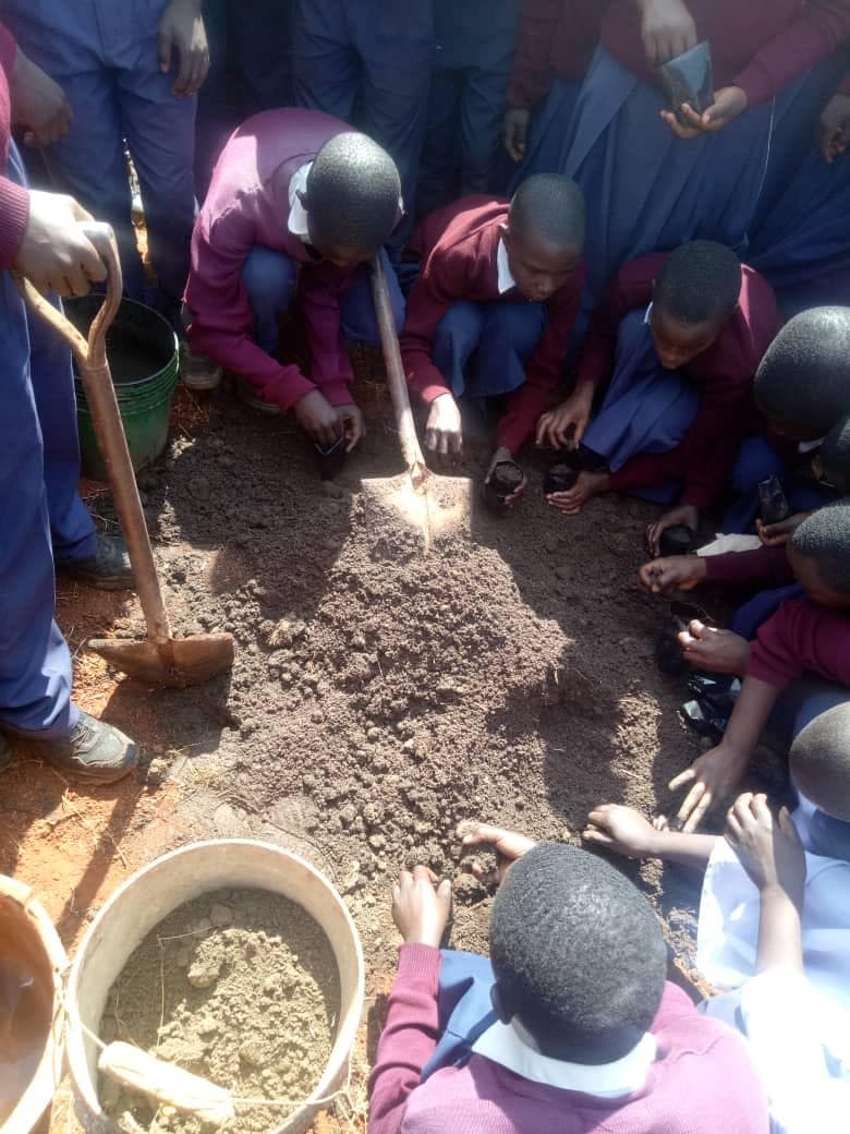 Students working together with soil and nursery bags.