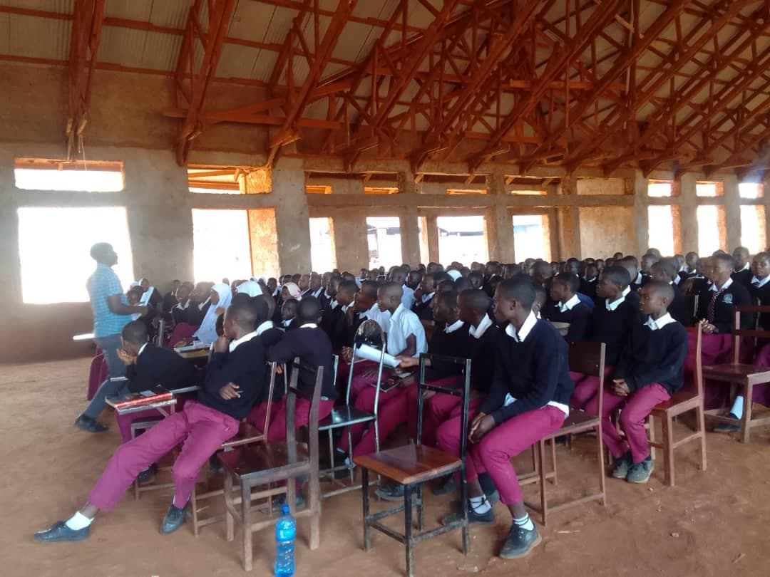 Students seated in a school hall during an environmental presentation.