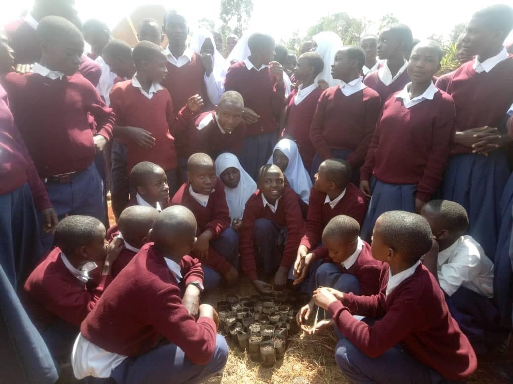 Students gathered closely around an outdoor practical activity.
