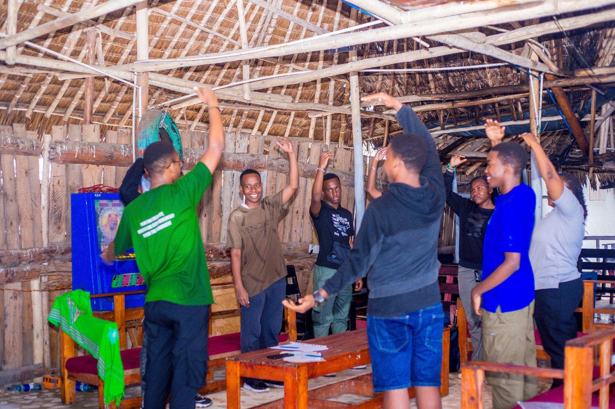 Participants raising their arms during a group activity in the meeting space.